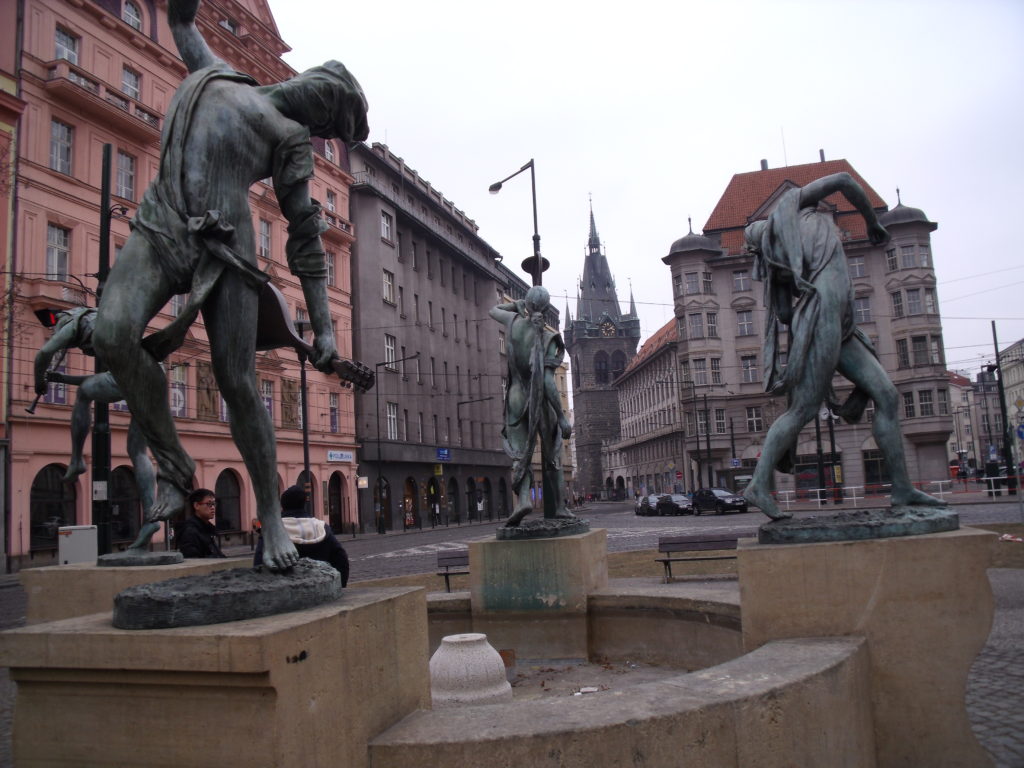 Czech Musicians dancing around a fountain.